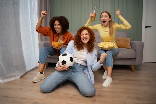 Groupe d'amies regardant du sport à la télévision via IPTV