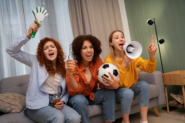 Groupe d'amies regardant du sport ensemble via IPTV à la maison