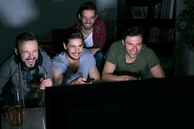 Groupe d'hommes regardant du sport avec bière via IPTV