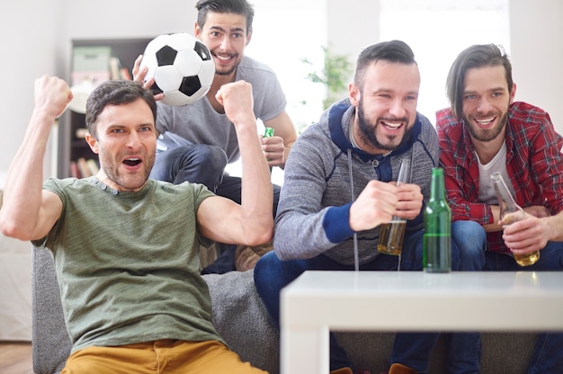 Groupe de jeunes hommes regardant un match à la télévision via IPTV