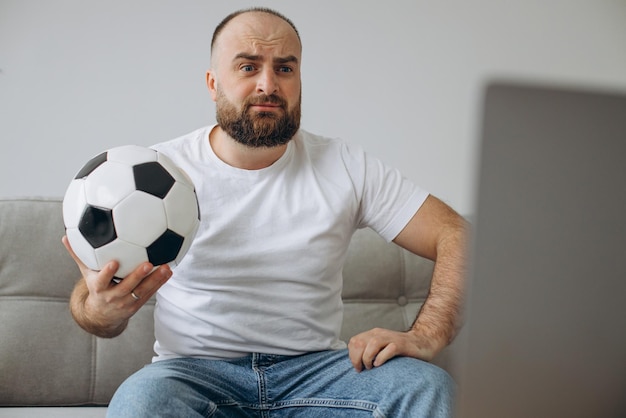 Homme regardant le football en streaming sur son téléviseur à domicile